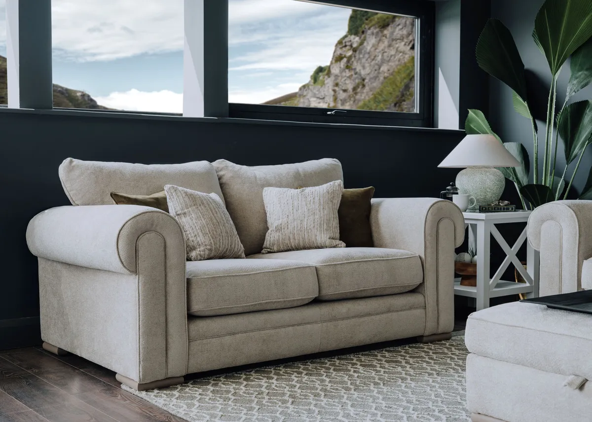 A lifestyle image of the Olivia small highback sofa with Hampton side table and Lee table lamp.