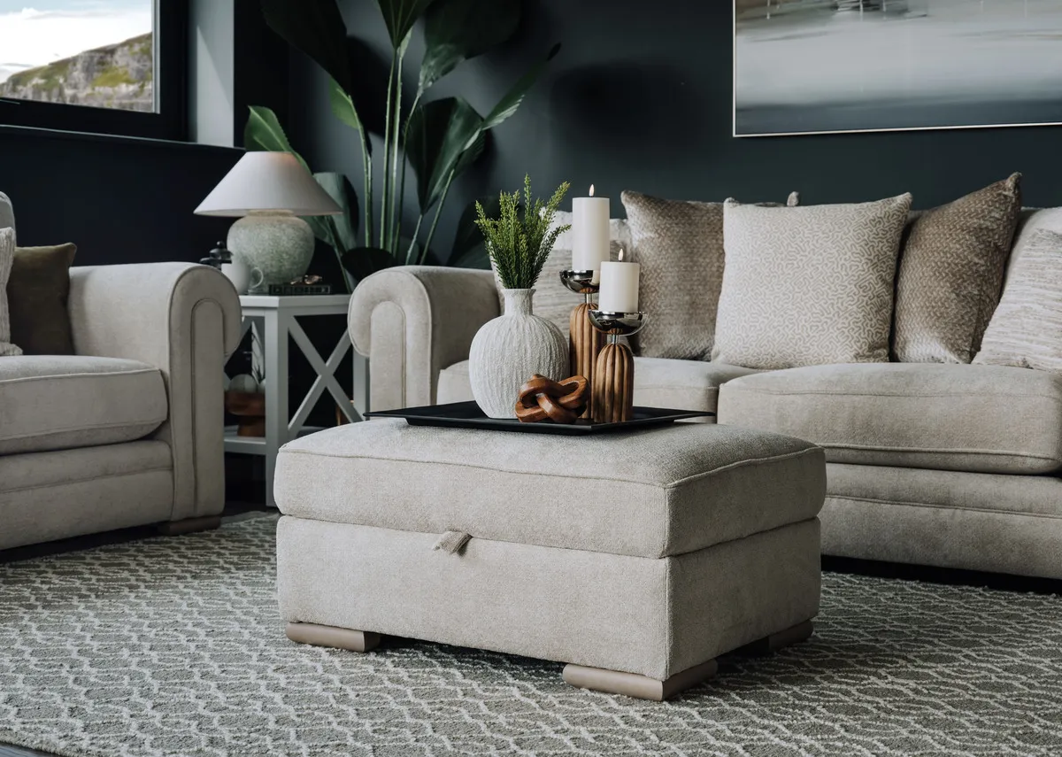 A lifestyle image of the Olivia footstool with lid closed and tray of accessories on top of seat cushion.