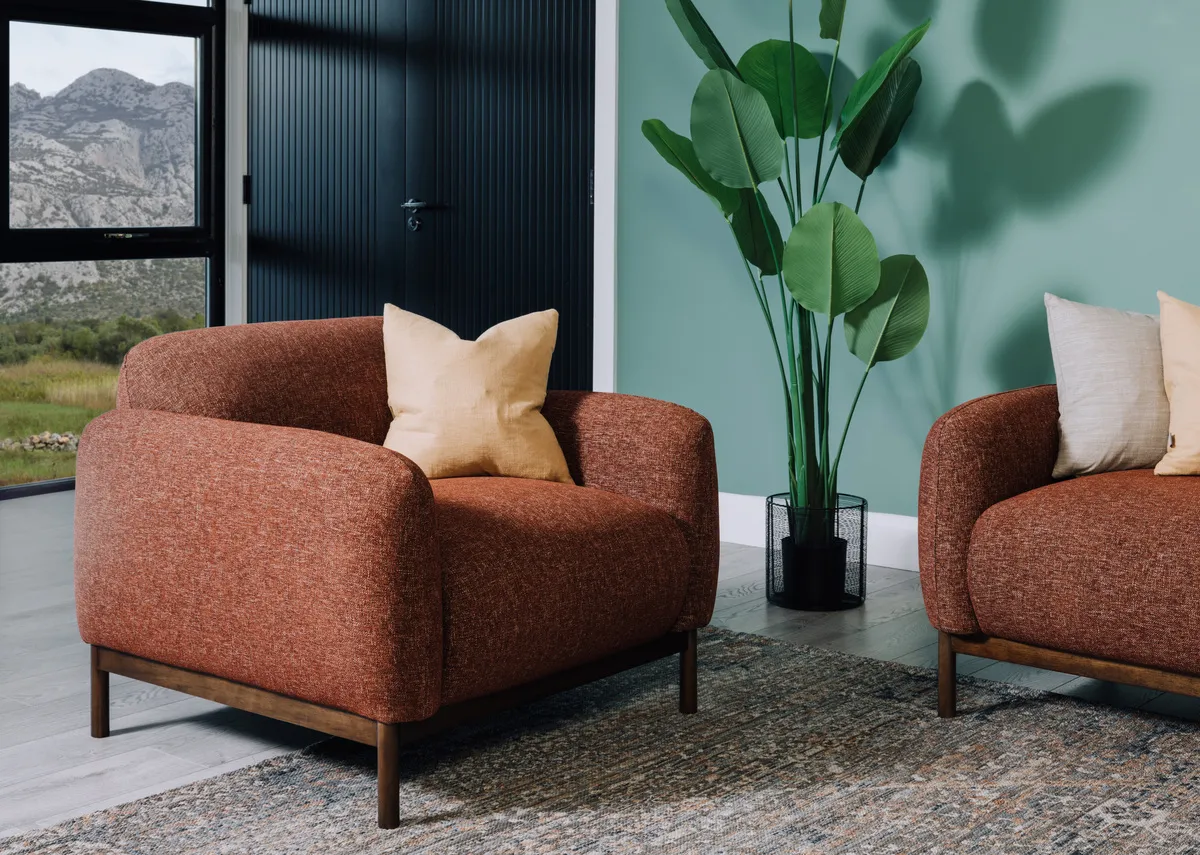 A lifetsyle image of the Loft armchair with sofa and Maxima rug.