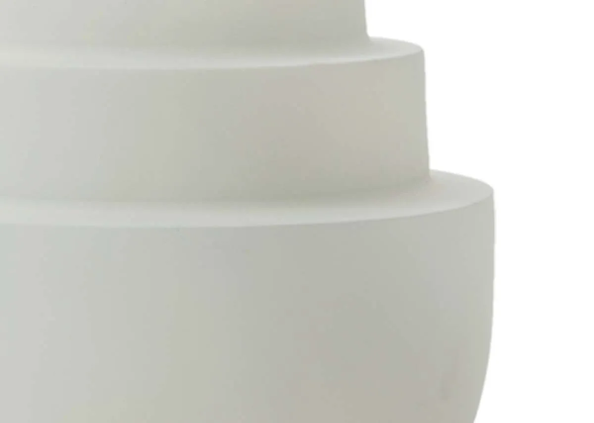 A close up detail of the concentric tiered sections of a  matt cream tealight holder.