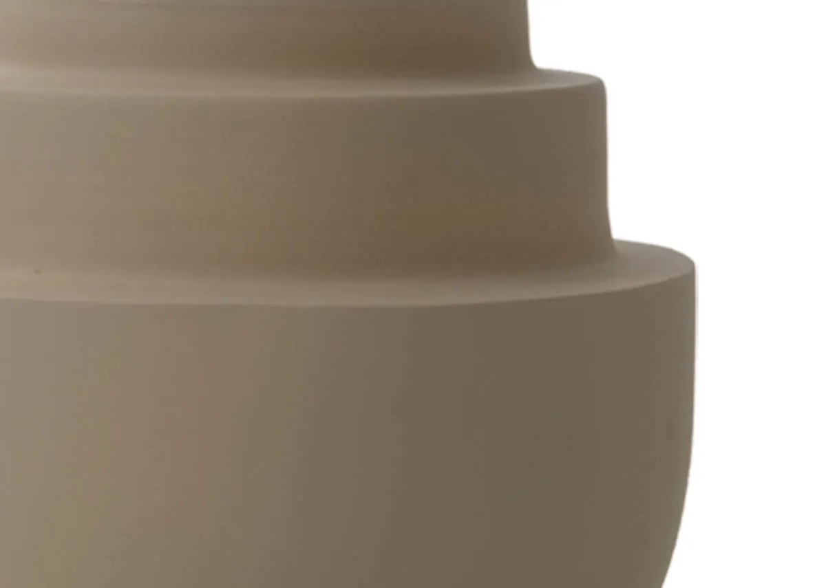 A close up detail of the concentric tiered sections of a small matt cream tealight holder.
