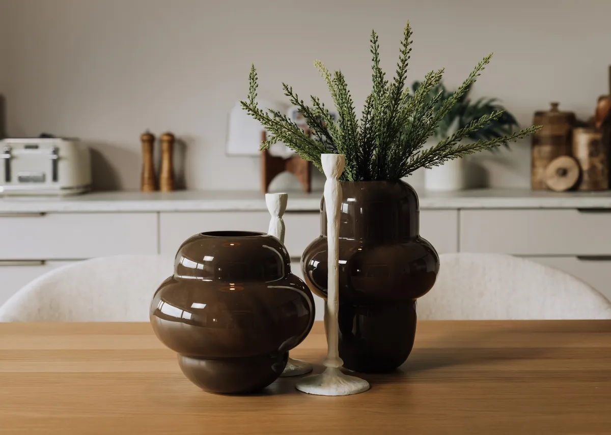 A lifetsyle image of the asolo candleholders with brown vases on a kitchen counter.