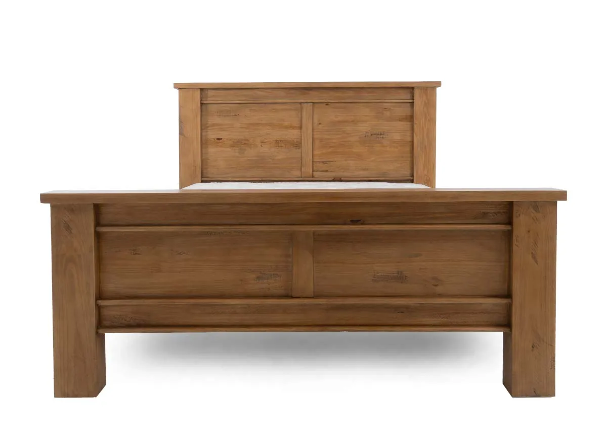 A side view of a light brown wooden bed frame with a headboard and footboard holding a white mattress.