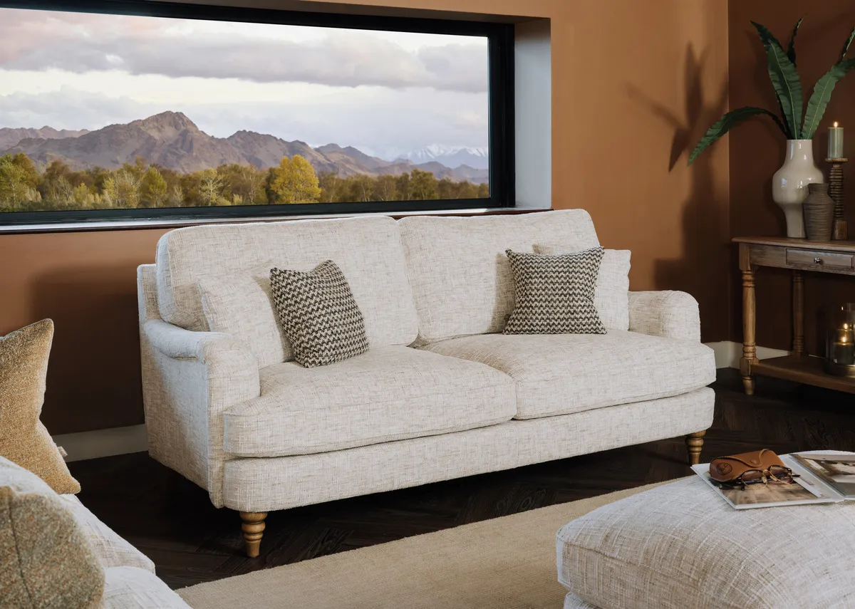 A lifestyle image of the Lismore 3 seater sofa with matching footstool.