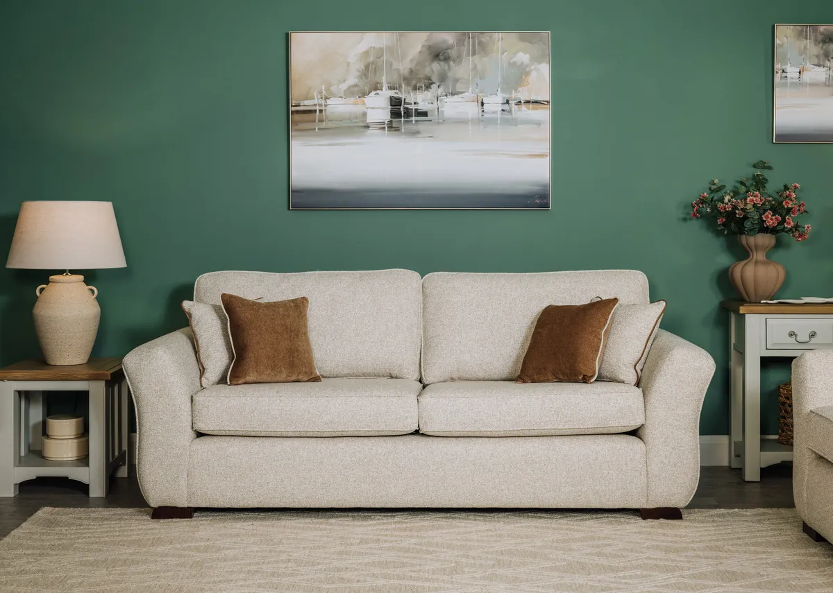 A lifestyle image of the Kilronan 4 seater sofa with gold cushions and Georgia lamp table with Mooring canvas.