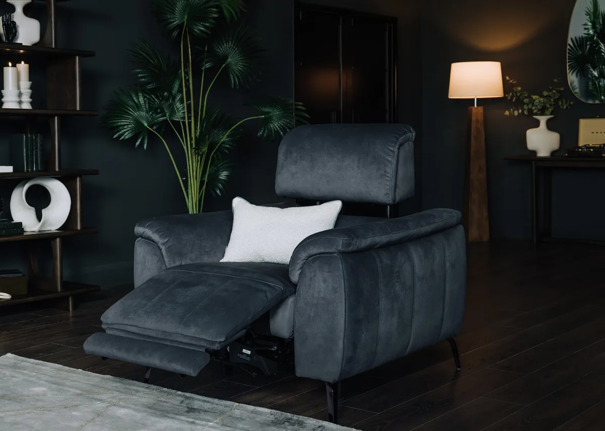 A lifestyle image of the Madison Recliner with seat extended paired with Expresso Flow bookcase.
