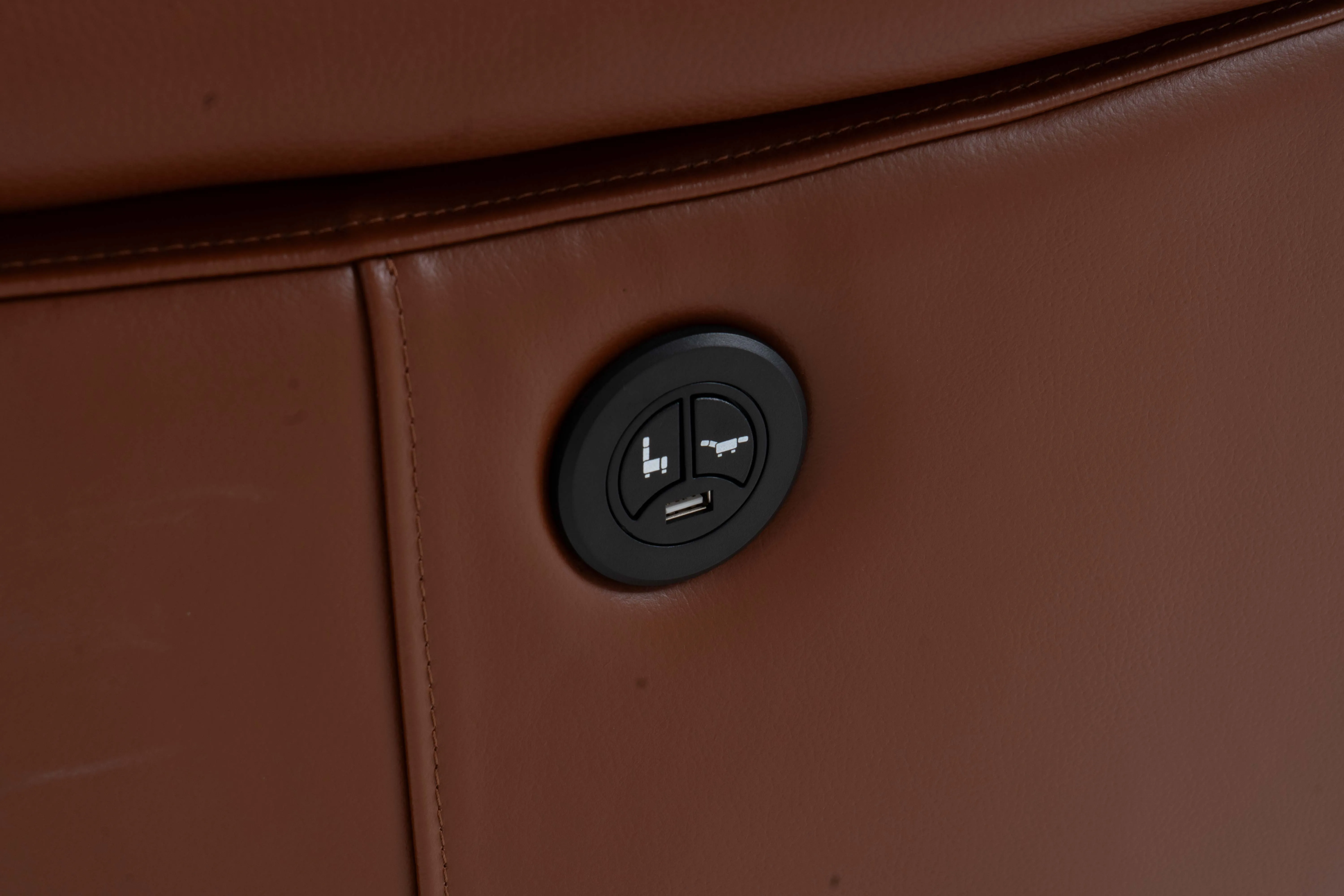 A brown leather recliner armchair from EZ Livings Blaze range. Closeup of remote control pad on side.