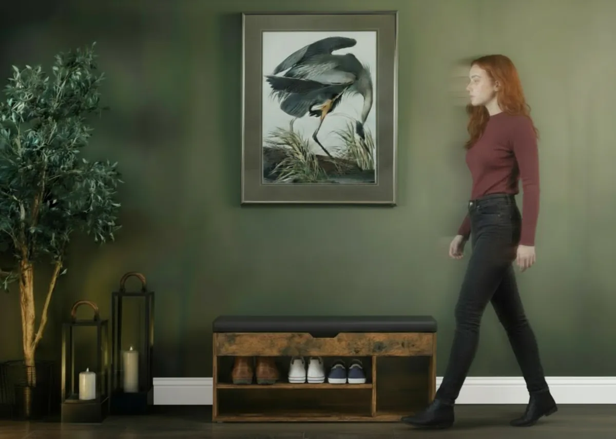 A lifestyle image of the Stash storage bench in a hallway with Heron picture.