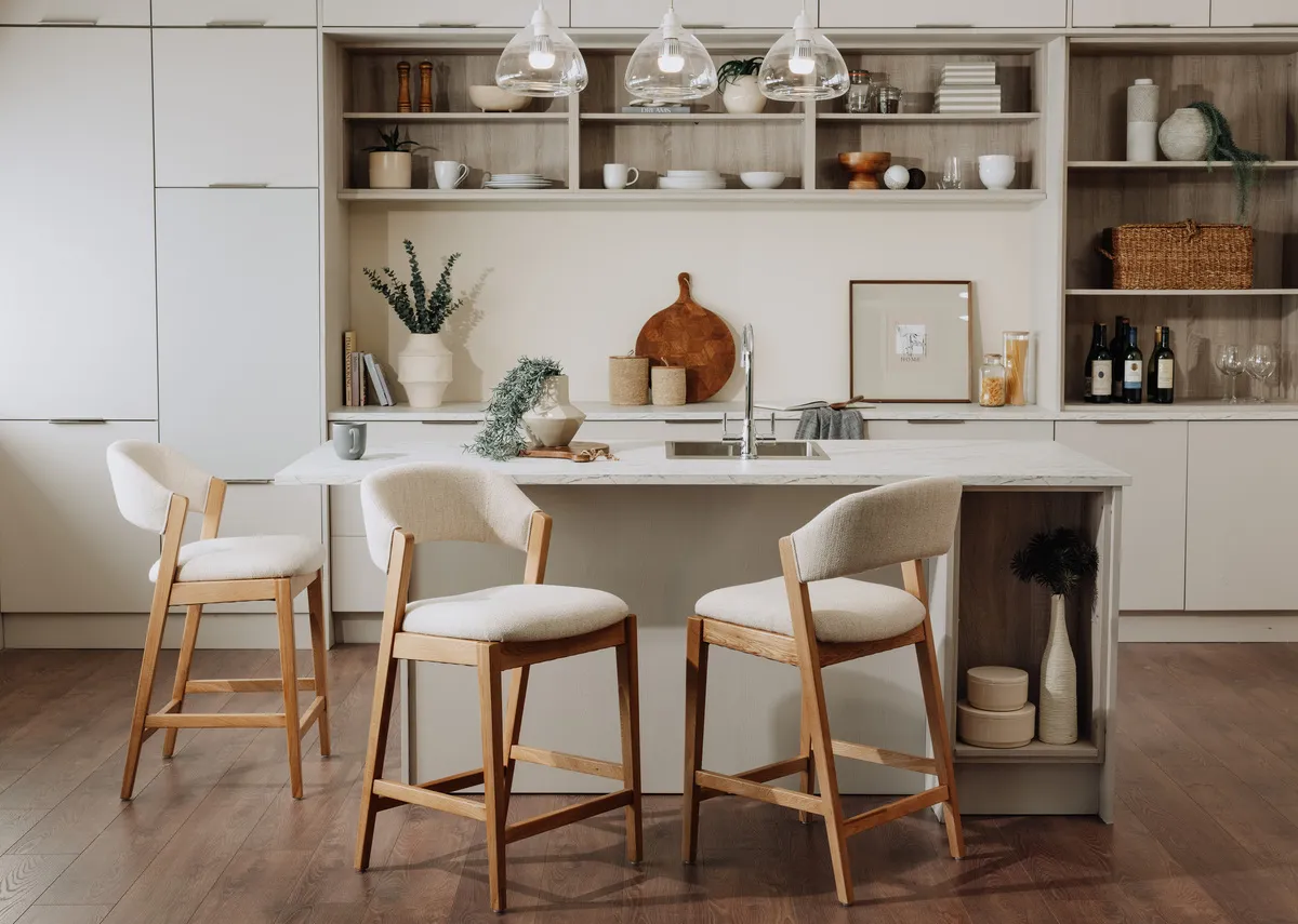 A lifestyle image of 3 Renvyle bar stools around a kitchen island in a kitchen.