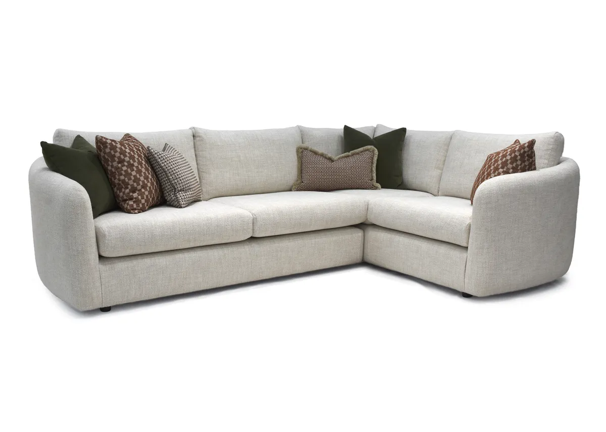 A cream boucle large rhf corner sofa with 6 scatters from EZ Livings Carnaby range. Angled view of spacious sofa.