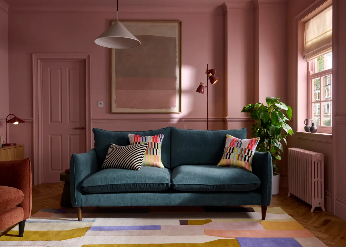 A lifetsyle image of the Kenmare sofa in large in a pink themed room with rust armchair.