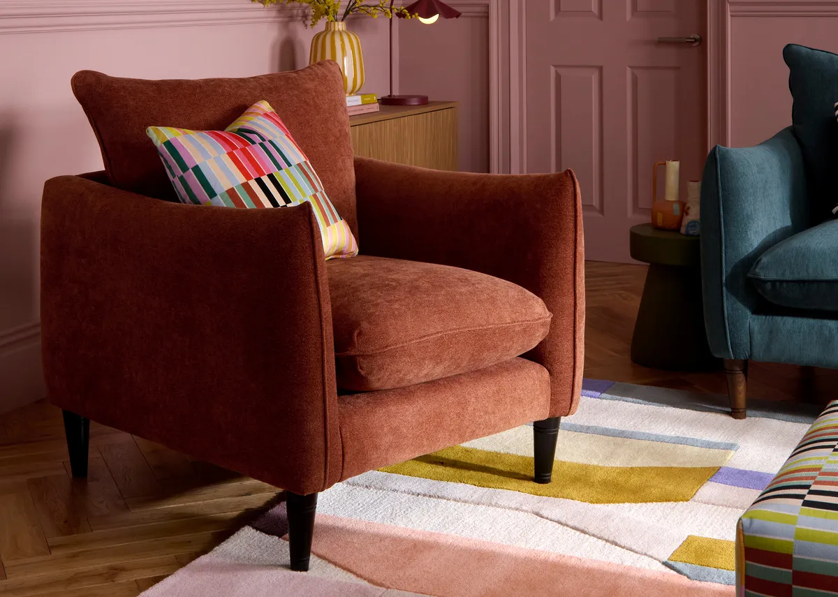 A lifestyle image of the Kenmare Armchair with multi cushion