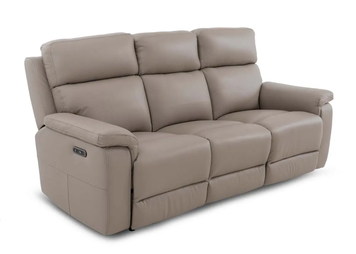A 3 seater leather power reclining sofa in a  fixed position from EZ Livings Raven range. Angled view of sofa in a light taupe.