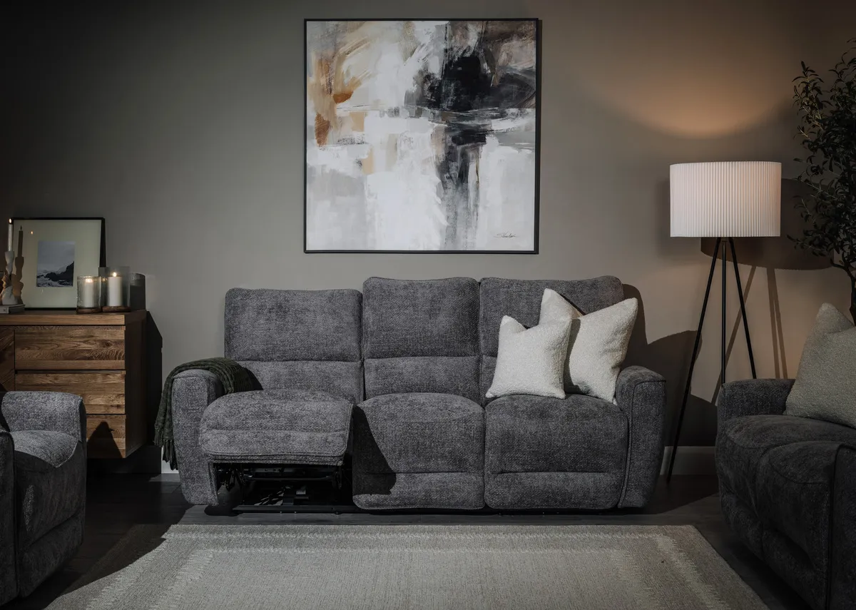 A lifestyle image of the Ashbrook 3 seater recliner sofa with Evocative print with Lura lamp.