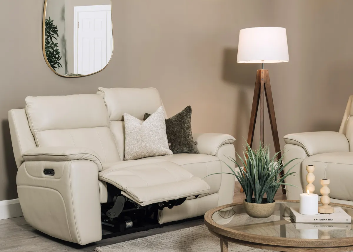 A lifetsyle image of the Aura leather 2 seater reclined with Alexis tables and Delfina mirror.