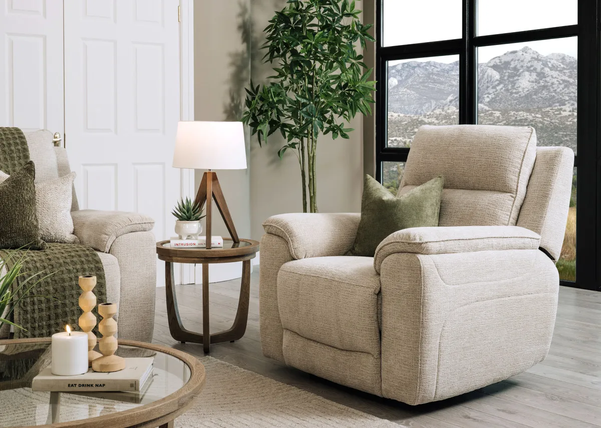 A lifestyle image of the Aura beige fabric armchair fully out with Alexis table and Glenveagh table lamp.