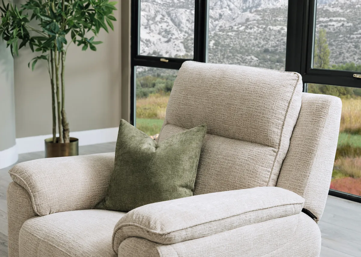 A lifestyle image of the Aura beige fabric recliner with a closeup on padded armrest and on the fabric finish.
