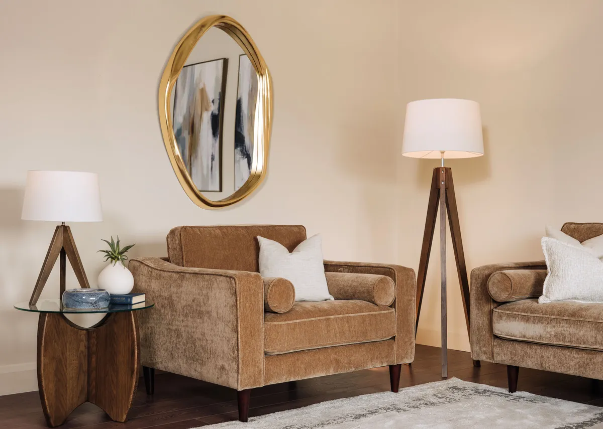 A lifestyle image of the Genoa armchair with Delphina mirror and Fauna lamp.