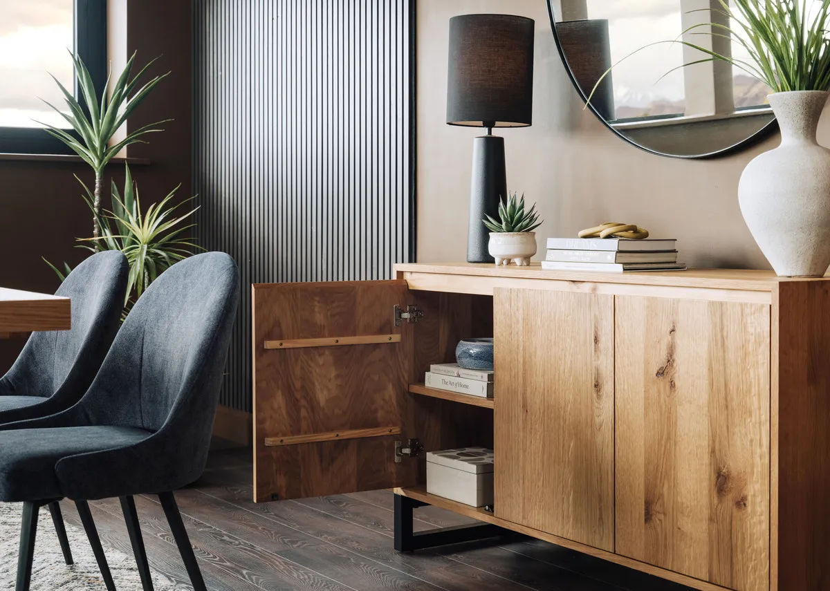 A lifestyle image of the Montana sideboard with door open showing space with Blackwater lamp and Jacon chairs