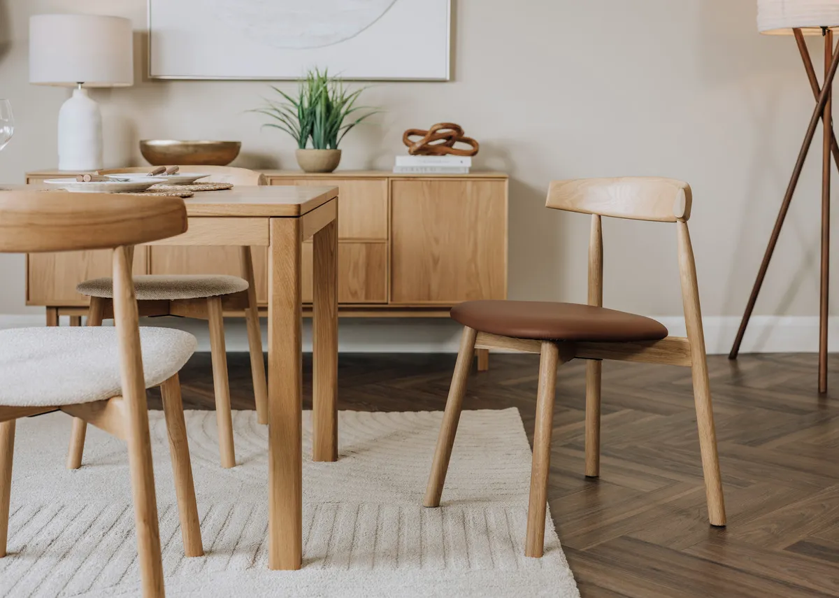 A lifestyle image of the Suri leather sdining chair with the Kari dining table and sideboard.