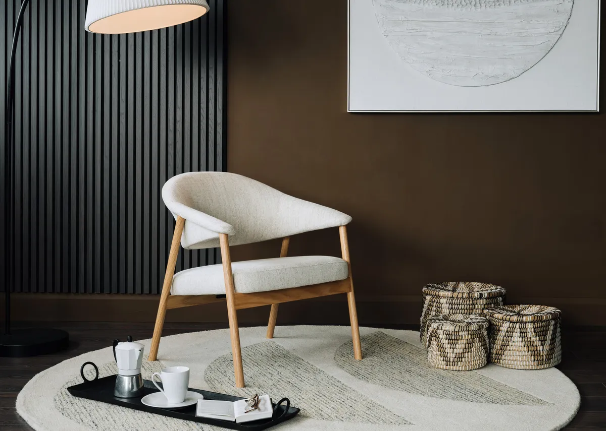 A lifestyle image of the Elk lounge chair with round rug and a slecetion of baskets.
