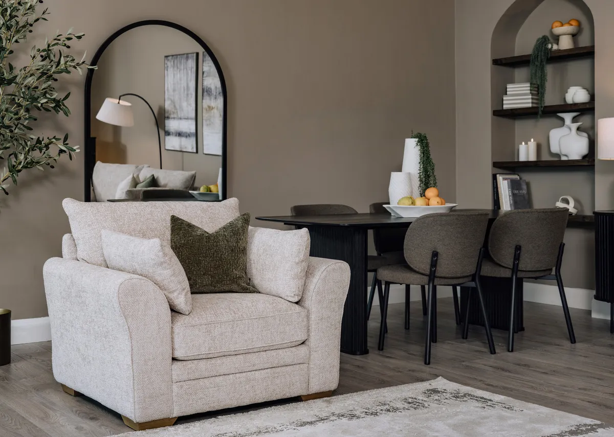 A lifestyle image of the New Skyline armchair with the Nola dining table and swan chairs in the background.