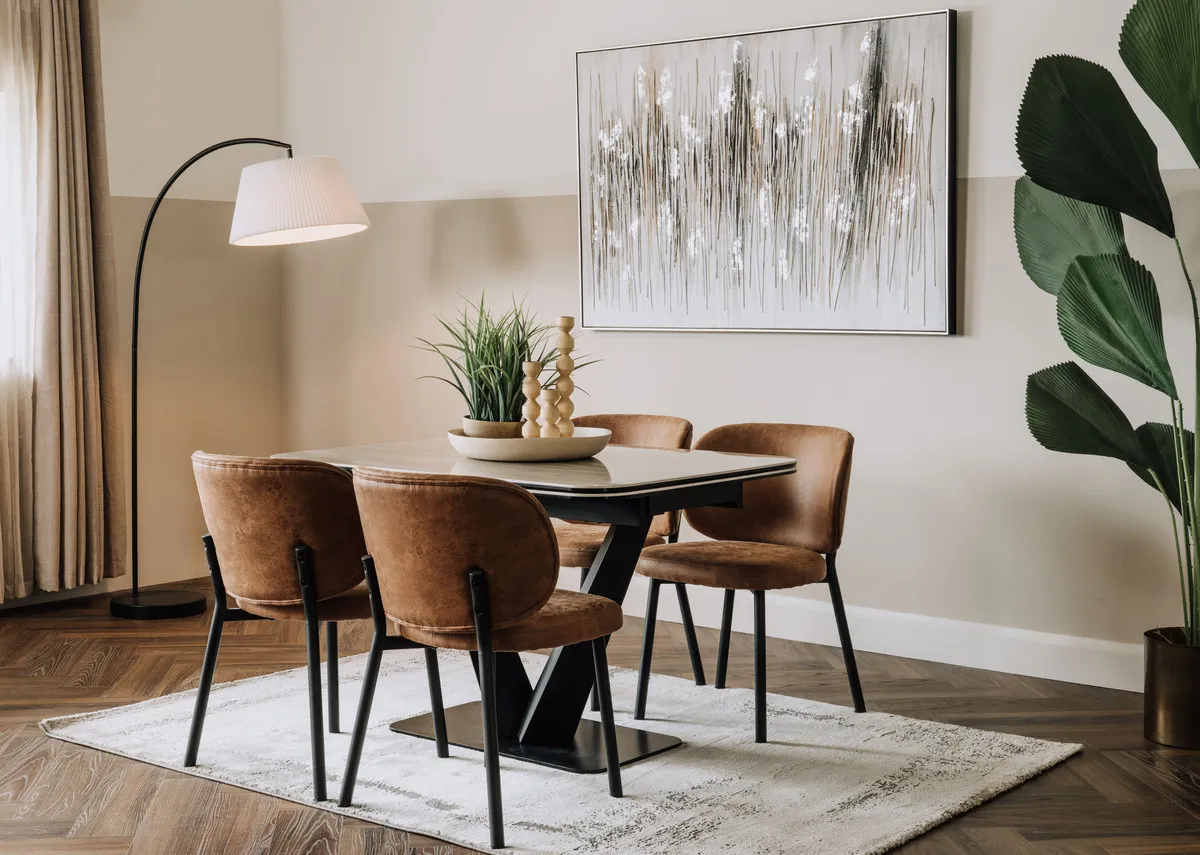 A lifestyle image of the Tusacn table with swan tan chairs and Tones of Grey