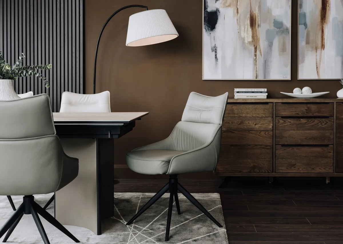 A lifestyle image of the Turin grey swivel chair with the Turin ceramic dining table.