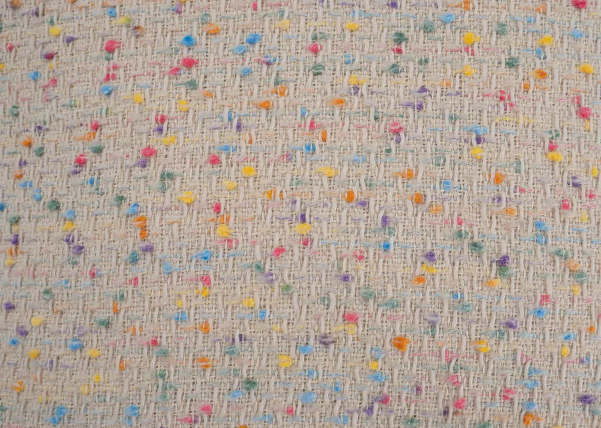 A cream cushion with multi coloured flecks from EZ Livings Honey Flax range.Closeup of confetti style flecks