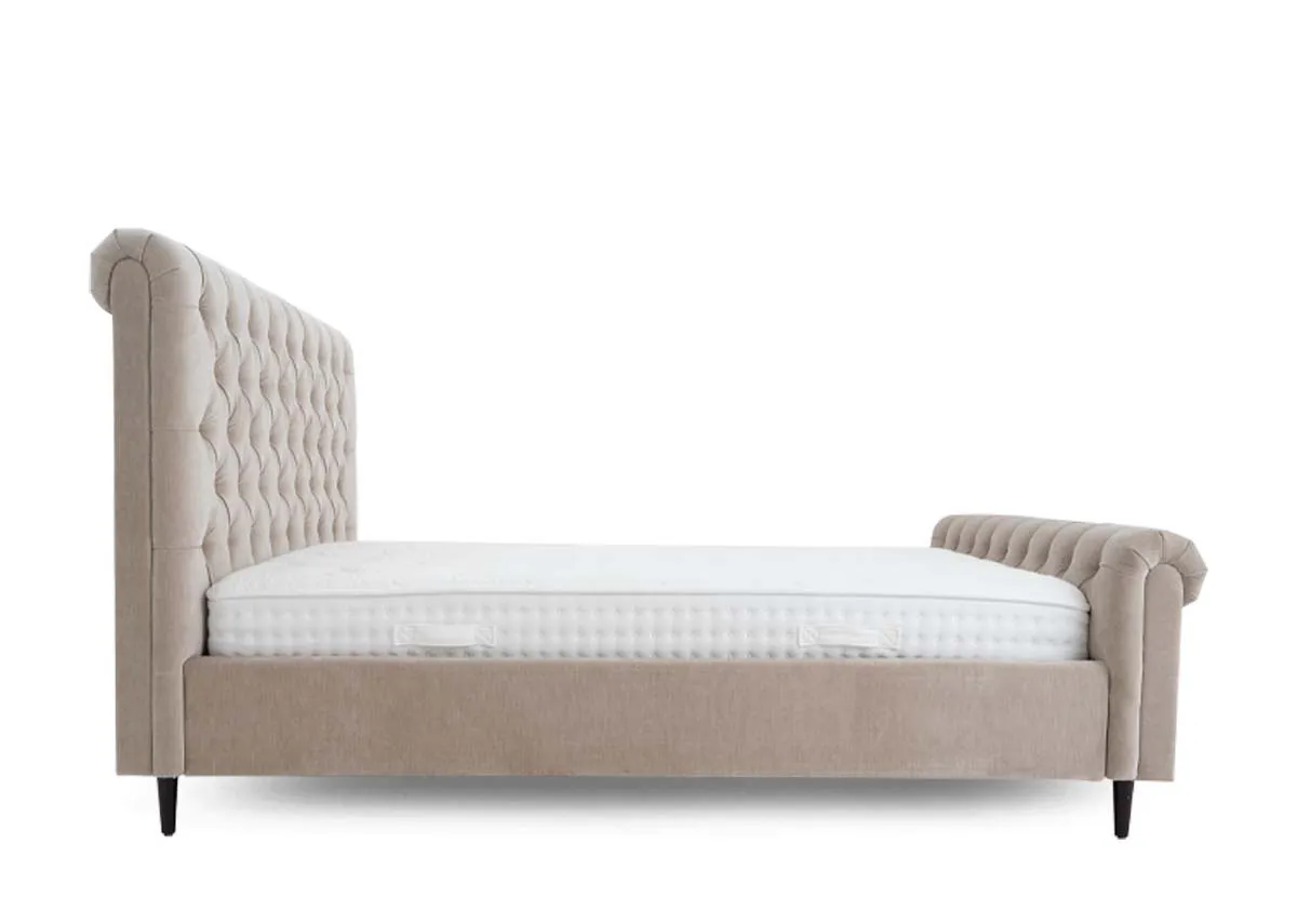 A double bed in taupe grey with button back detail from EZ Livings Sofia range. Side view of roll top headboard and foot board.
