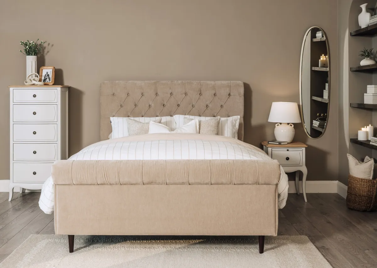A lifestyle image of the Sofia taupe bedframe with Amelie chests and Lana mirror.