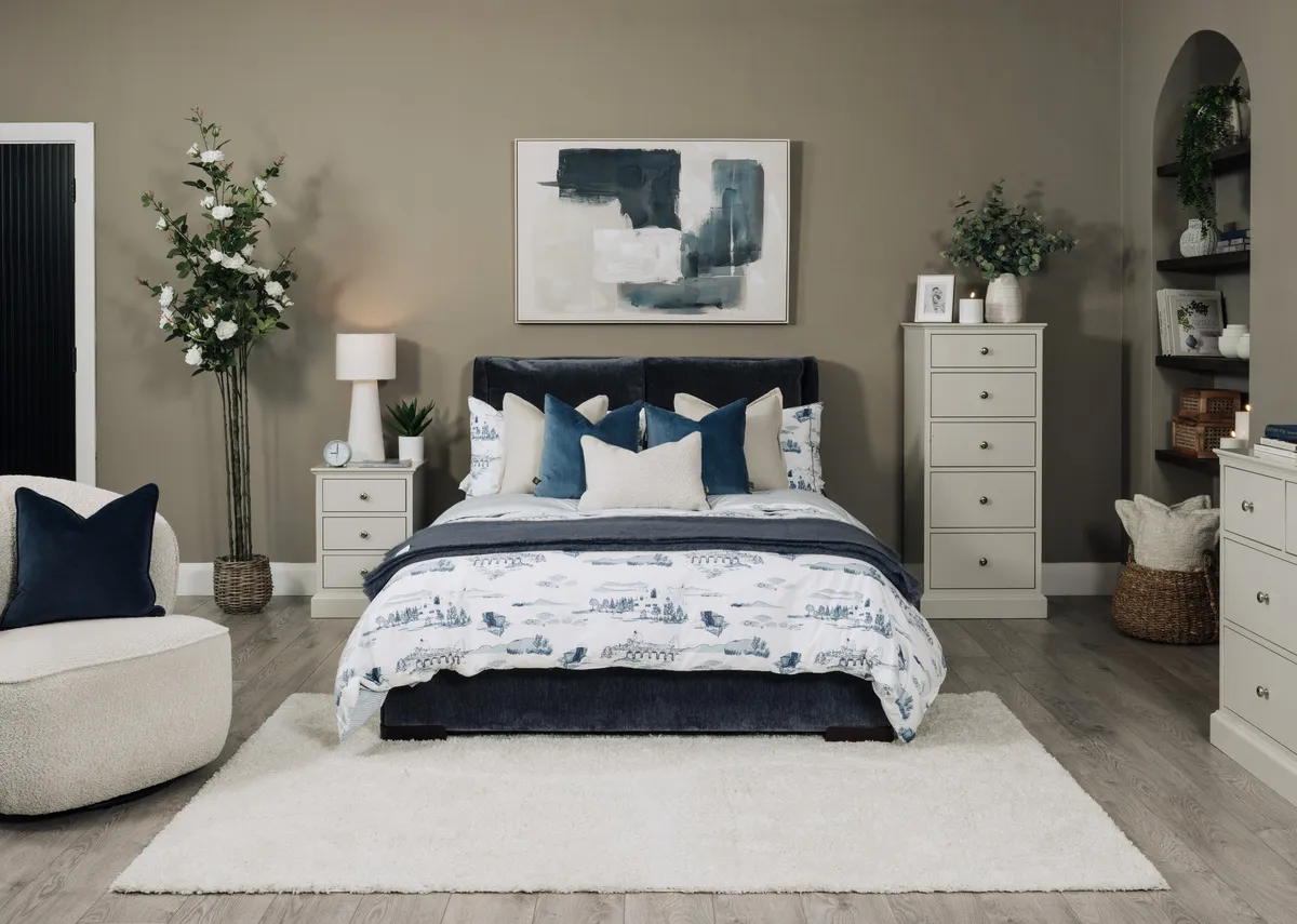 A lifestyle image of the Comfy blue bedframe with Foxford toile duvet set and Riverdale locker and chests.