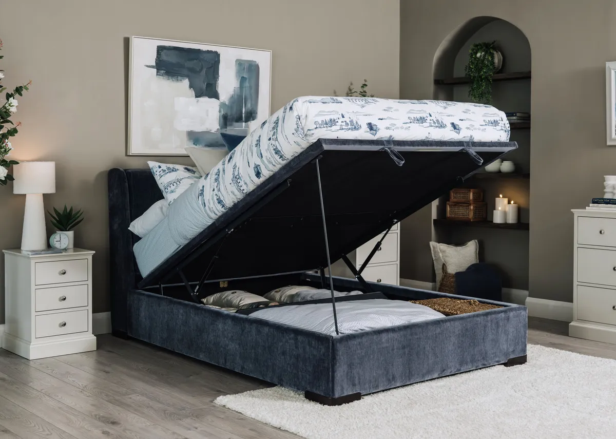 A lifestyle image of the Comfy blue ottoman bed with Foxford toile duvet set with storage open showing available space.