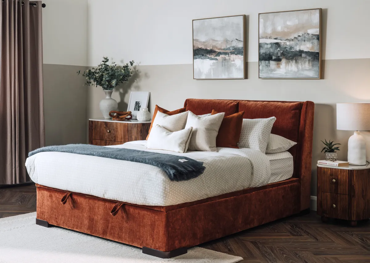 A lifestyle image of the Comfy Rust Ottoman with the bed closed with the Nora locker and chest.