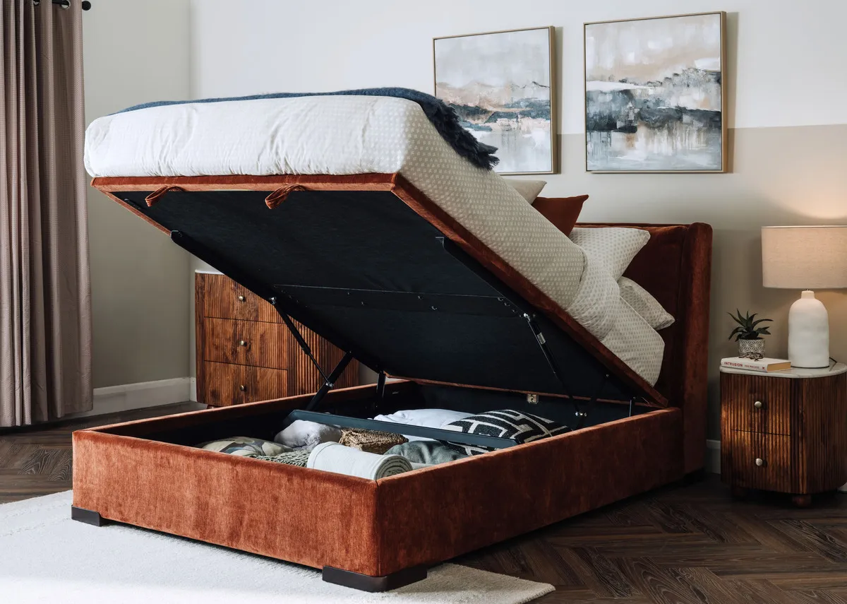 A lifestyle image of the Comfy Rust Ottoman with the bed open to reveal hidden storage.