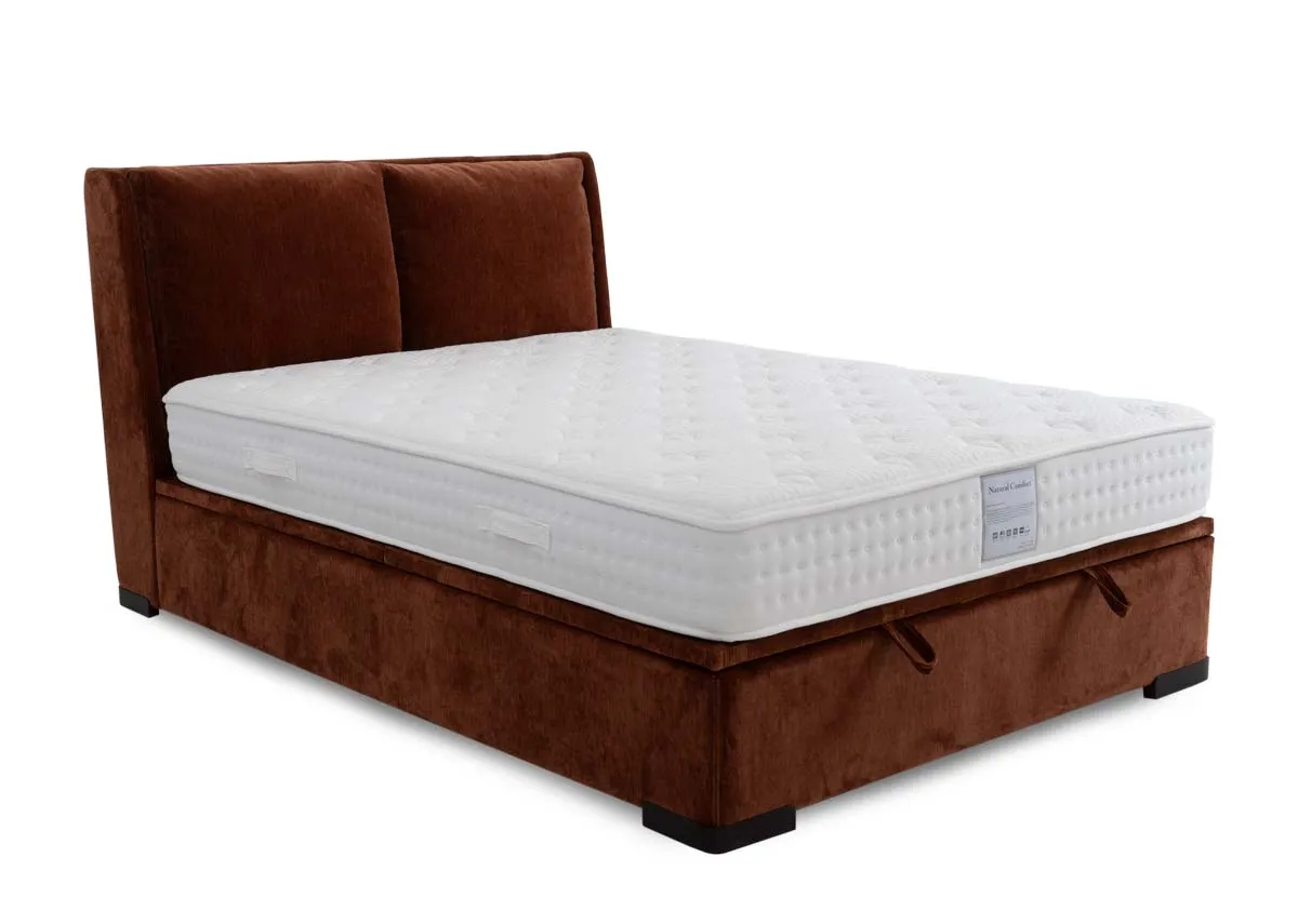 A rust velvet fabric ottoman bed with padded headboard from EZ Livings Comfy range. Angled view of high base with room beneath mattress for storage.