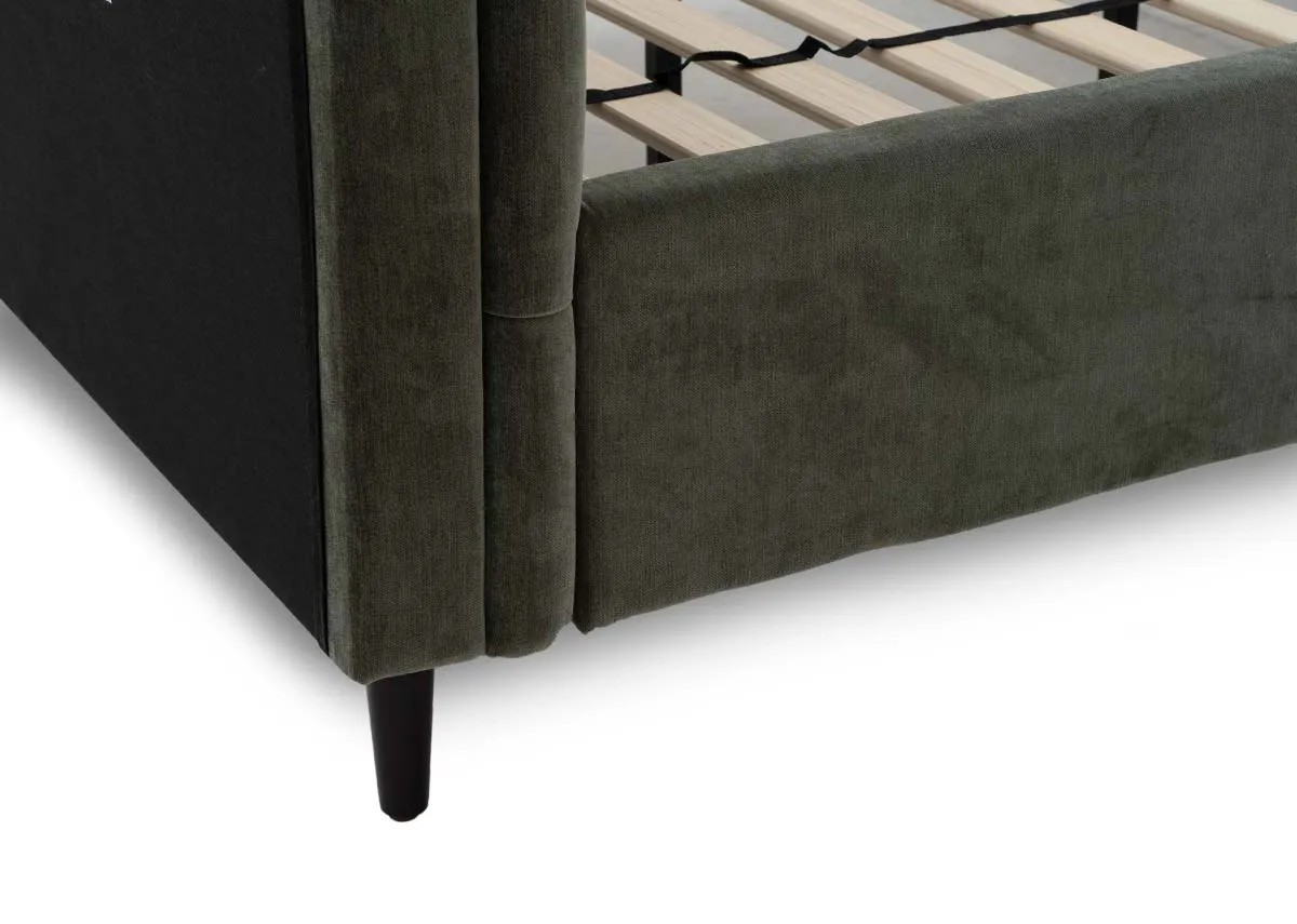 A green fabric bedframe with tufted Chesterfield detail and scrolled finish head and footboard. Closeup of walnut feet