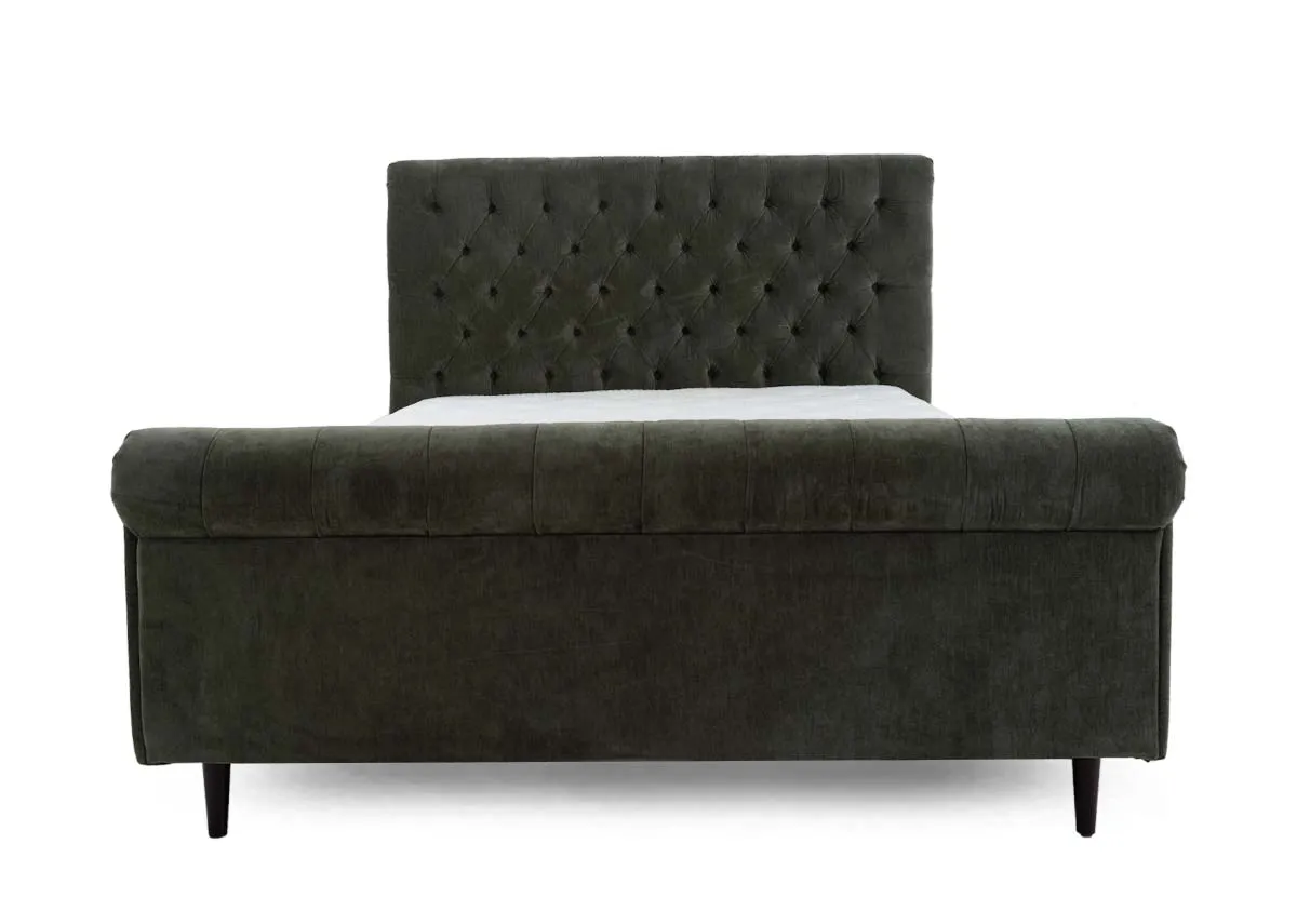 A green fabric bedframe with tufted Chesterfield detail and scrolled finish head and footboard. Front view of EZ Livings Furnitures Sofia bed.