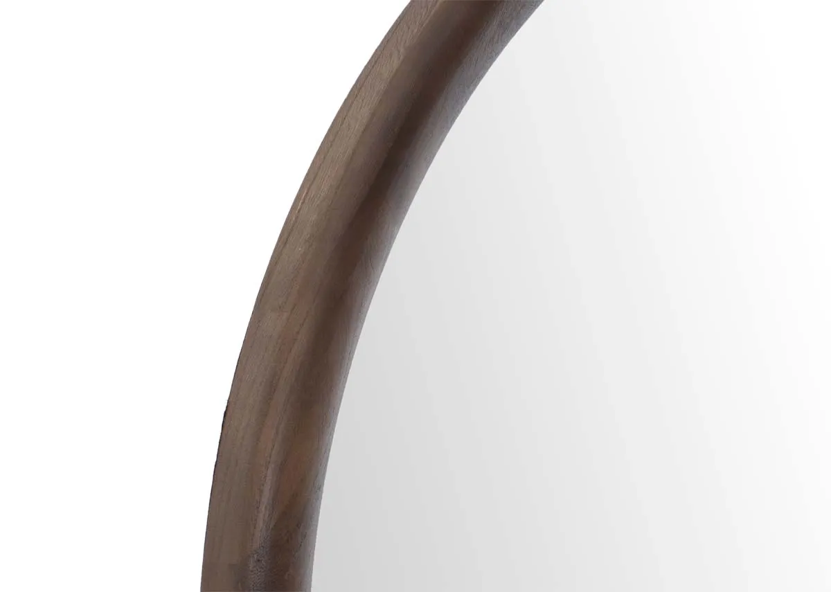 An arched walnut framed mirror closeup on wood frame.