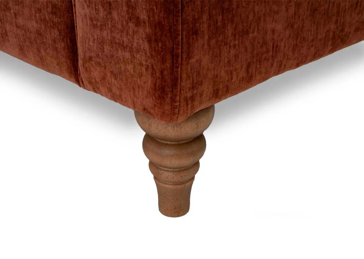 A rust fabric corner sofa from EZ Livings Cotswold range. Closeup of wooden leg