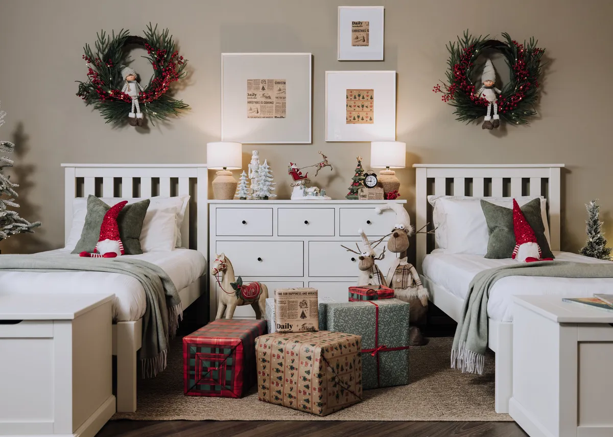 A lifestyle image of the Atlas single bed with chest with Slany lamp with resin tree and gifts ornament with trees.
