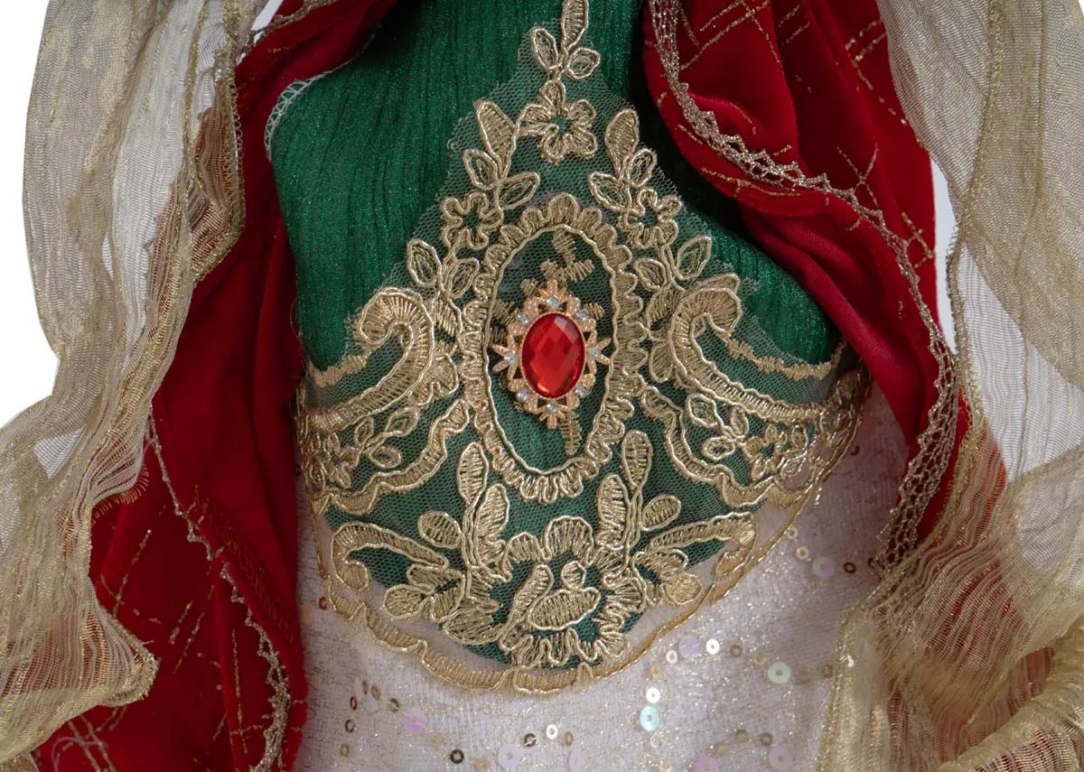 A traditional angel tree topper from EZ Livings Christmas range.Closeup of red gold and green detail