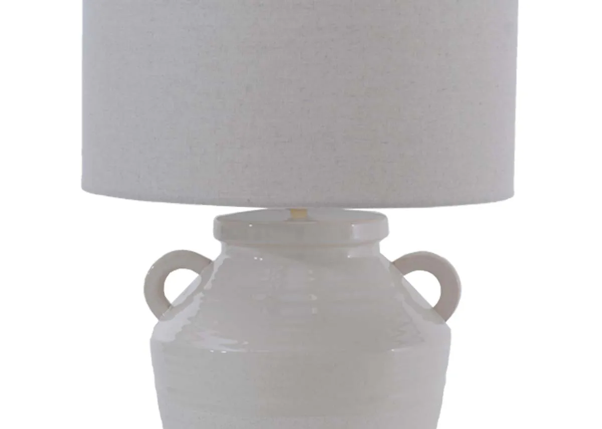 A closeup of the neutral cream drum shade and small hook urn handles on the lamp base of the Ballindine lamp.