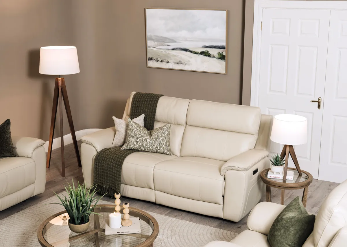 A lifestyle image of the Aura leather 3 seater foxed with Alexis tables and Glenveagh lamps.