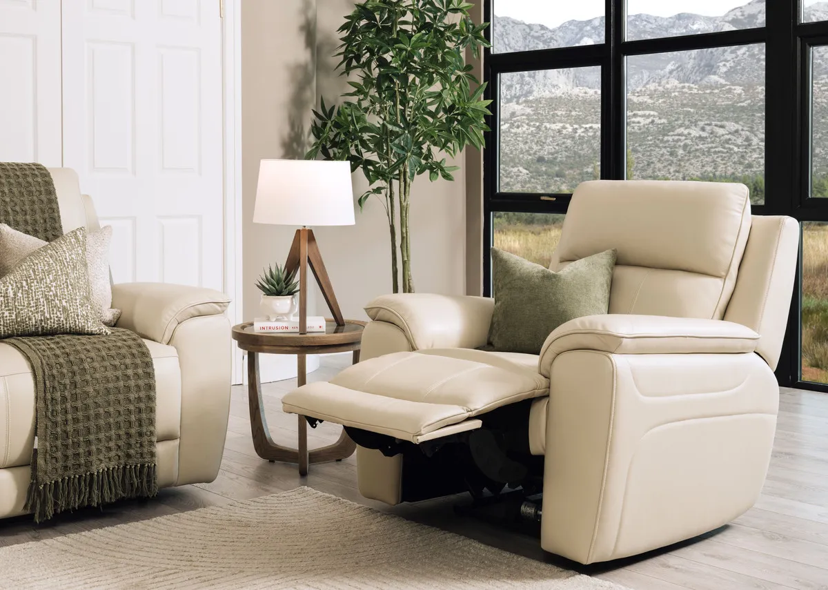 A lifestyle image of the Aura leather recliner with leg up with Alexis table and Glenveagh lamp.