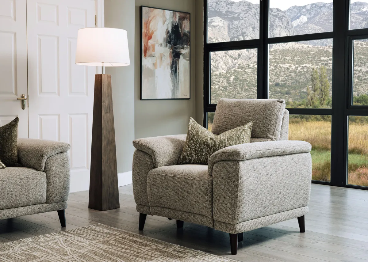 A lifestyle image of the Savoy fabric recliner as fixed armchair with the Fauna lamp.
