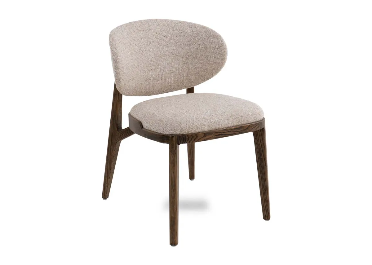 A beige fabric dining chair with ashwood frame. Angled view of padded seat and curved backrest