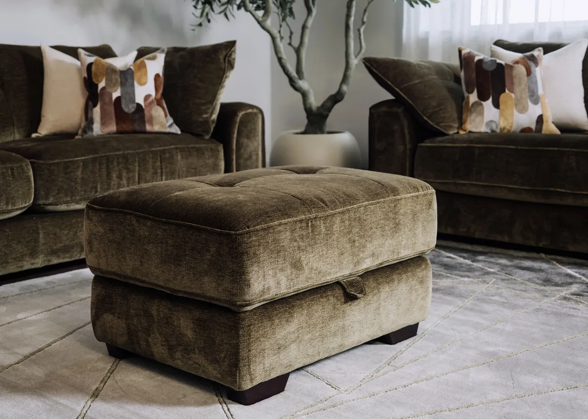 A lifetsyle image of the Darcy olive green footstool closed as a seat with tufted button detailing.