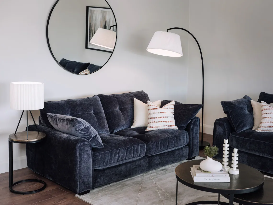 A lifestyle image of the Darcy sofa with arc and starleet lamps with elling mirror