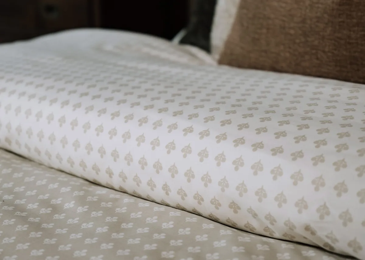 A lifestyle image of the Foxford Mia duvet set on the Ebony bed with a selection of cushions.